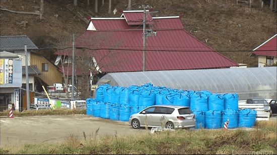 道端や農地に置かれた黒や青い袋の山