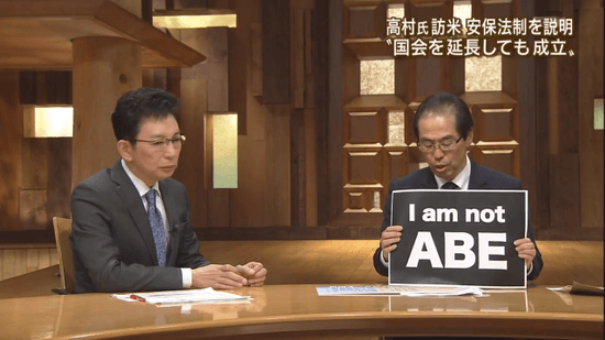 「I am not ABE」のフリップを掲げる 古賀茂明氏